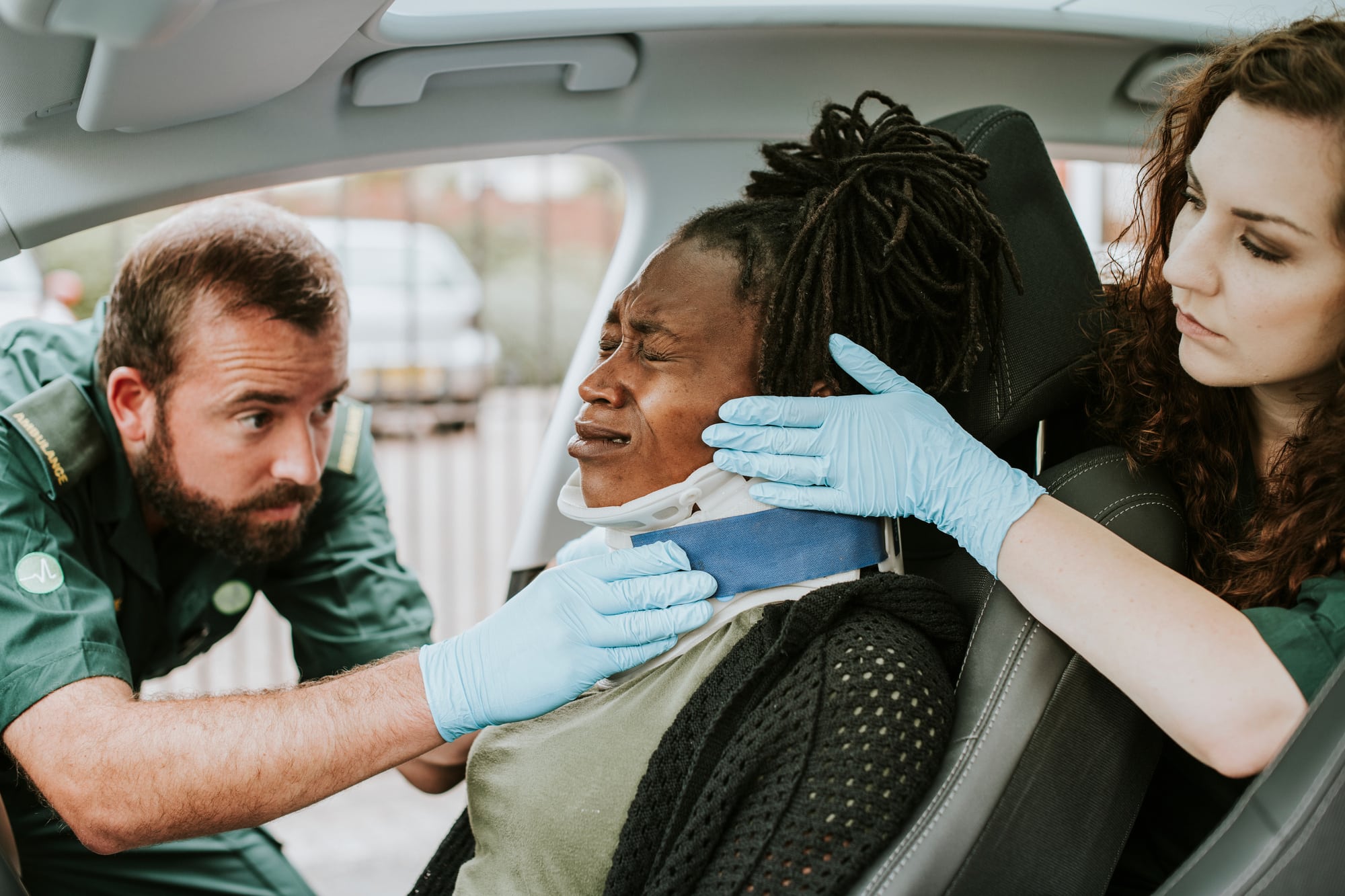 Paramedic placing a cervical collar to an injured woman from car accident
